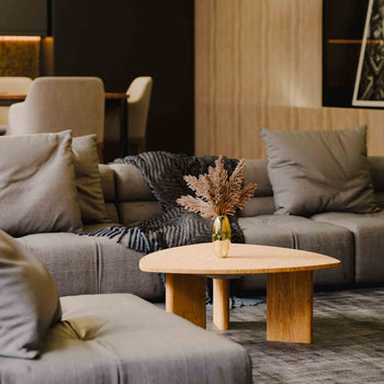 Modern living room with gray sofa, wooden coffee table, and decorative elements.