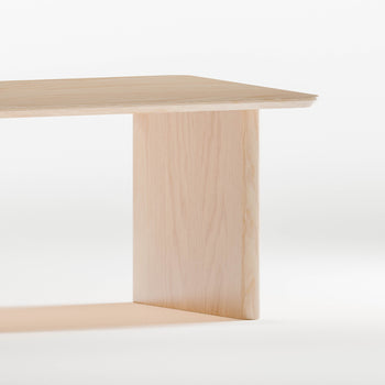 Closeup of solid maple wood table with a minimalist design on a white background