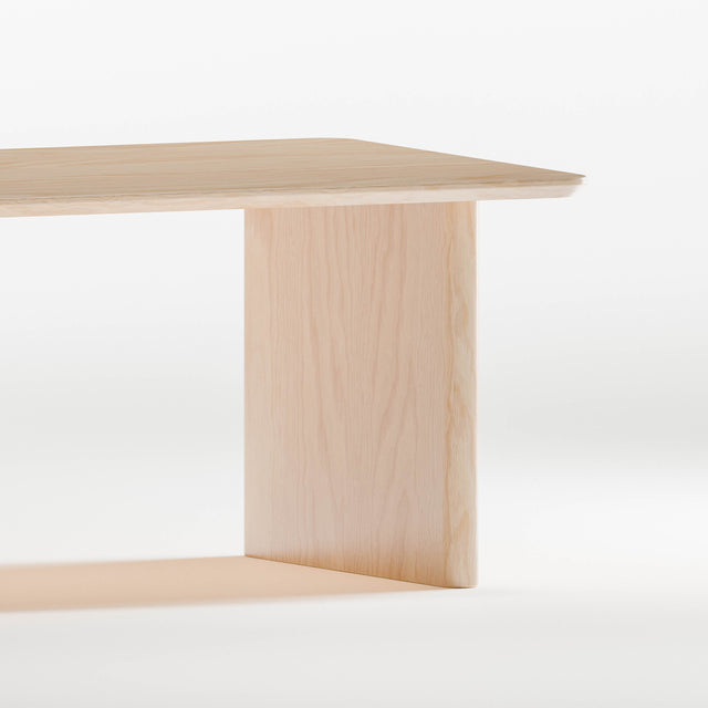 Closeup of solid maple wood table with a minimalist design on a white background