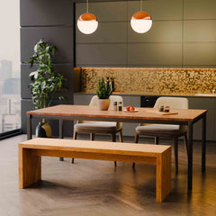 Modern kitchen with wooden bench, dining table and bench, pendant lights, and decorative elements.