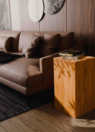 Brown leather sofa with a wooden side table in a modern living room.