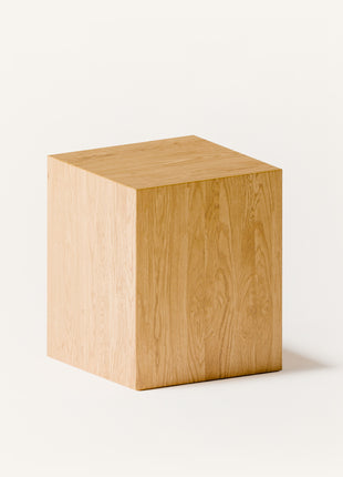 Solid oak stool with rounded edges and sturdy base, angled side view in a contemporary living room with modern wood furniture