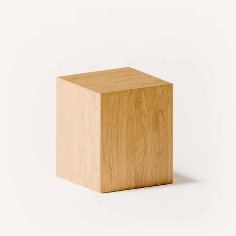 Solid oak stool with rounded edges and sturdy base, angled side view in a contemporary living room with modern wood furniture