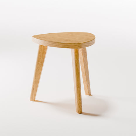 Solid oak stool with rounded edges and sturdy base, angled side view in a contemporary living room with modern wood furniture