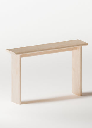 Maple solid wood console table used in a living room as a narrow display table with decor and modern wood furniture