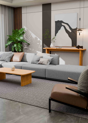 Modern living room with a gray sectional sofa, wooden console table, wooden coffee table, and decorative elements.