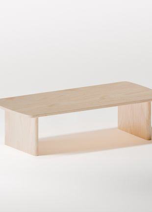 Minimalist solid wood coffee table in maple with simple rectangular shape, styled in a bright living room with modern wood furniture