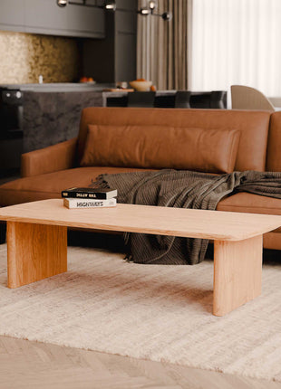 Brown leather sofa with a wooden coffee table in a living room setting.