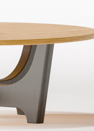 Modern wood coffee table in solid oak placed in front of a light fabric sofa, styled with a tray and candle in a cozy living room