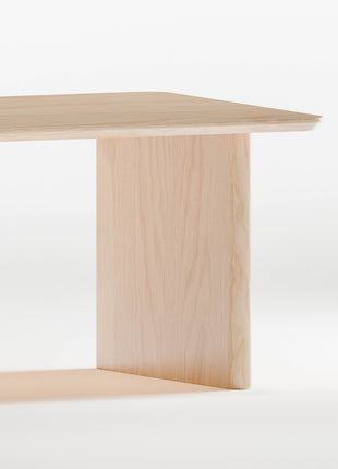 Closeup of solid maple wood table with a minimalist design on a white background