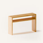 Modern solid wood console table in oak with clean lines and natural finish, styled in a minimalist entryway with mirror and ceramic decor