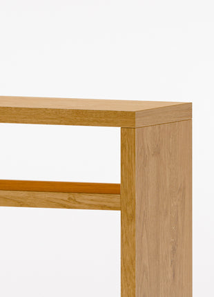 Modern solid wood console table in oak with clean lines and natural finish, styled in a minimalist entryway with mirror and ceramic decor