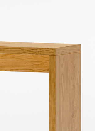 Modern solid wood console table in oak shown from front view, emphasizing clean profile and balanced proportions in a minimalist home