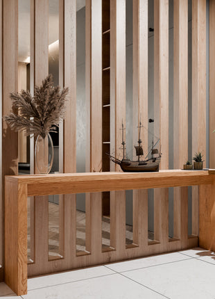 Modern wood furniture piece featuring a solid wood console table in oak, styled with books and a vase in a contemporary entryway