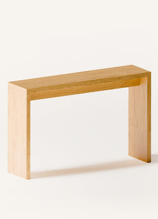 Modern solid wood console table in oak shown from front view, emphasizing clean profile and balanced proportions in a minimalist home