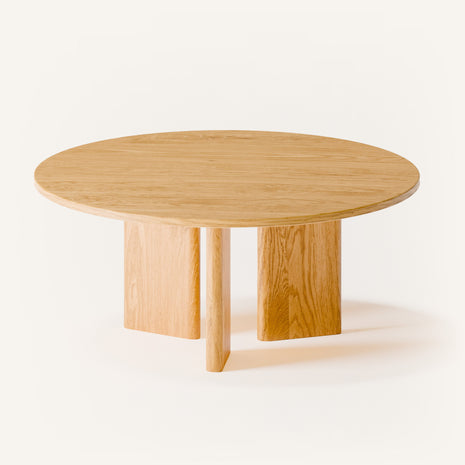 Modern wood coffee table in solid oak placed in front of a light fabric sofa, styled with a tray and candle in a cozy living room