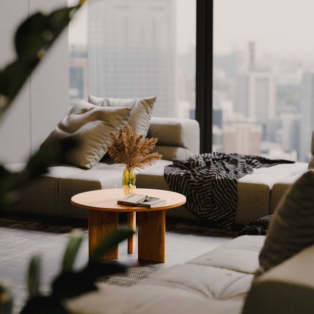 Modern living room with a sofa, coffee table, and cityscape view.