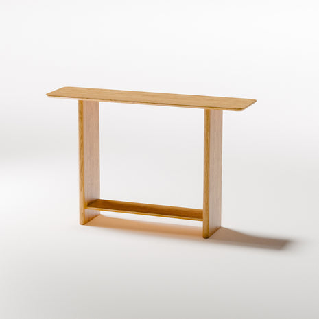 Modern solid wood console table in oak shown from front view, emphasizing clean profile and balanced proportions in a minimalist home