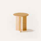 Modern solid wood end table in oak with clean lines and natural finish, styled beside a sofa in a minimalist living room