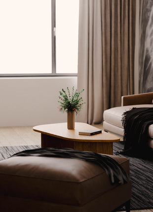 Modern living room with a sofa, ottoman, and solid wood coffee table.